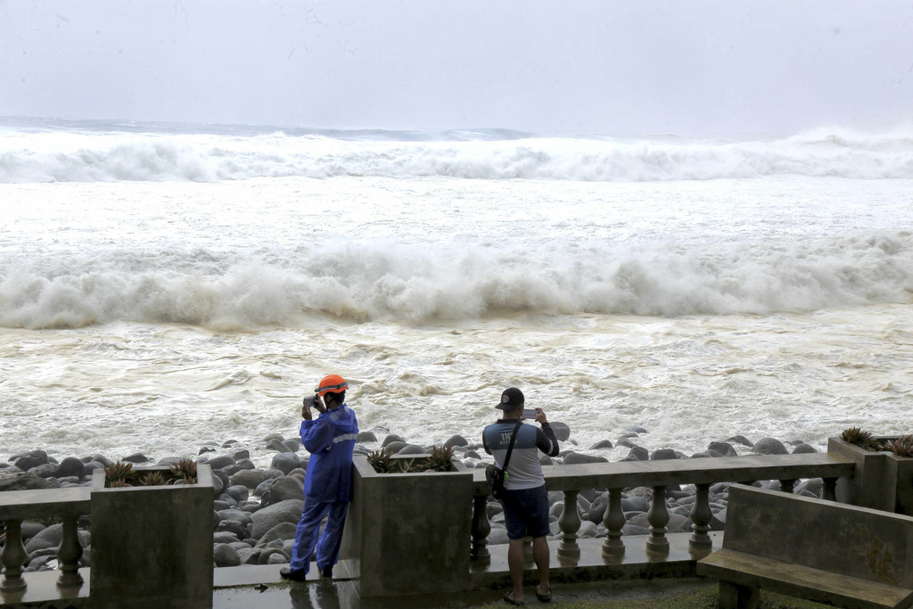 CORRECTS DATE - People watch as strong waves batter Basco, Batanes province, northern Philippines as Typhoon Ragasa affects the area on Monday, Sept. 22, 2025. (AP Photo/Justine Mark Pillie Fajardo)