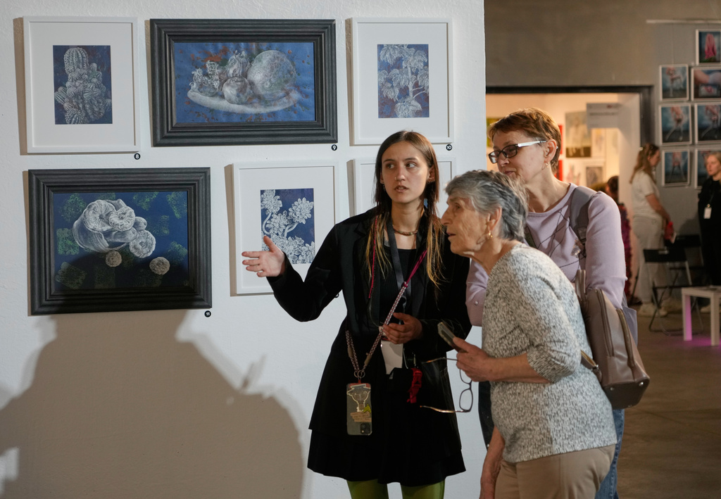 Visitors look at paintings by Ukrainian artists at the Art Kyiv 2026 Festival at the Art Ukraine Gallery in Kyiv, Ukraine, Friday, May 8, 2026. (AP Photo/Efrem Lukatsky)