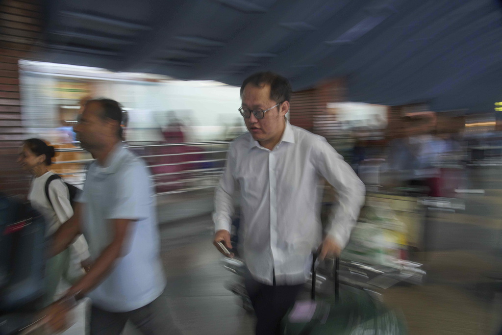 A tourist runs to catch a flight after after Nepal's international airport which was closed due to nationwide protests reopens in Kathmandu, Nepal, Thursday, Sept. 11, 2025. (AP Photo/Niranjan Shrestha)