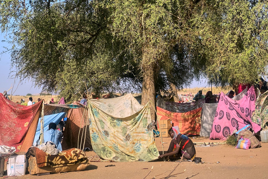 A Sudanese who fled el-Fasher city, after Sudan's paramilitary forces killed hundreds of people in the western Darfur region, ties her tent at her camp in Tawila, Sudan, Sunday, Nov. 2, 2025. (AP Photo/Mohammed Abaker)