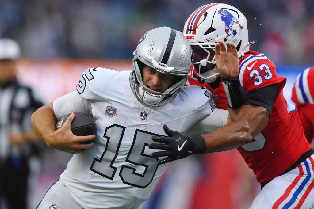 Las Vegas Raiders quarterback Fernando Mendoza (15) runs with the ball as New England Patriots safety Mike Brown (33) defends during the second half of an NFL football game in Foxborough, Mass., Sunday, Oct. 11, 2026. (AP Photo/Steven Senne)