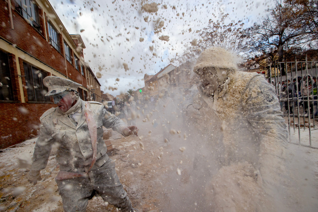 Revellers take part in the Els Enfarinats festival, a battle using flour, eggs and firecrackers, in the town of Ibi near Alicante, Spain, Sunday Dec. 28, 2025. (AP Photo/Alberto Saiz)