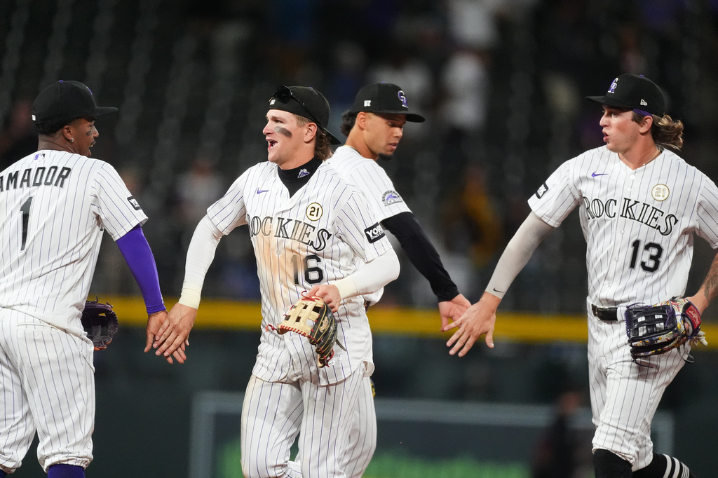 From left, Colorado Rockies second baseman Adael Amador congratulates center fielder Cole Carrigg as shortstop Ezequiel Tovar commends right fielder Zac Veen after defeating the San Diego Padres in a baseball game Tuesday, Sept. 15, 2026, in Denver. (AP Photo/David Zalubowski)