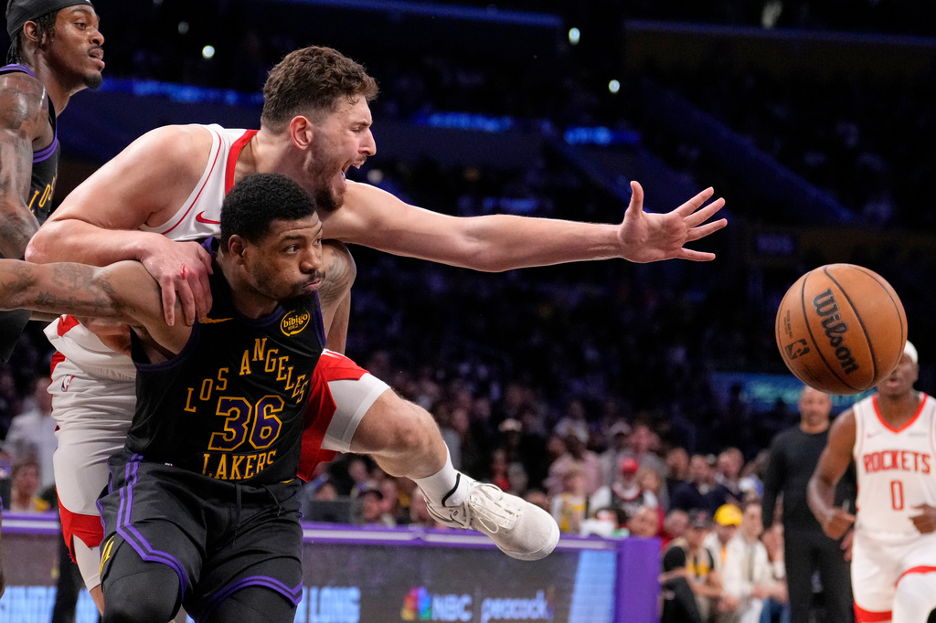 Houston Rockets center Alperen Sengun, top, and Los Angeles Lakers guard Marcus Smart go after a rebound during the first half in Game 2 of a first-round NBA playoffs basketball series Tuesday, April 21, 2026, in Los Angeles. (AP Photo/Mark J. Terrill)
