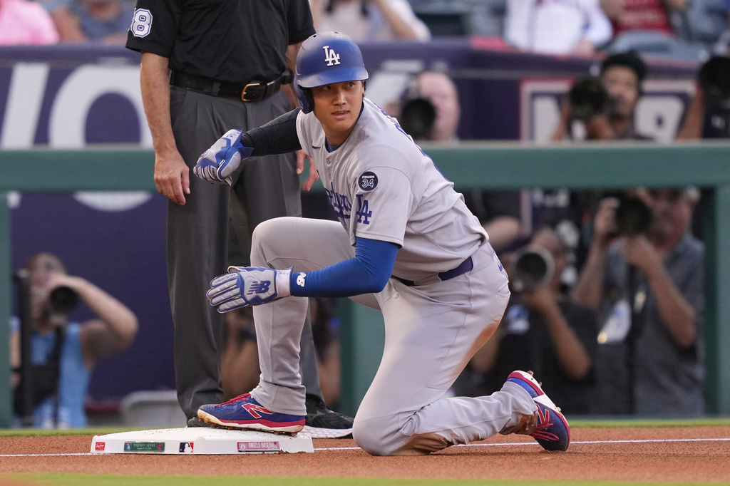 Los Angeles Dodgers' Shohei Ohtani looks up after sliding into third while advancing on a sacrifice fly hit by Freddie Freeman during the first inning of a baseball game against the Los Angeles Angels, Tuesday, Aug. 12, 2025, in Anaheim, Calif. (AP Photo/Mark J. Terrill)