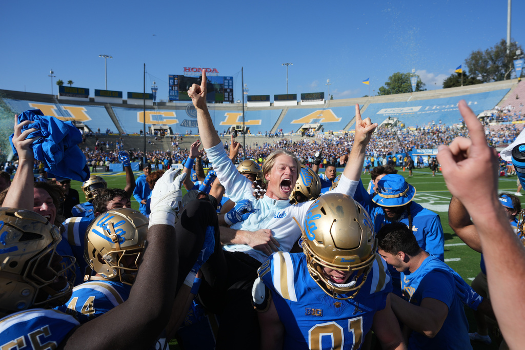 UCLA coach Jerry Neuheisel is lifted by players after a win over Penn State during an NCAA college football game Saturday, Oct. 4, 2025, in Pasadena, Calif. (AP Photo/Marcio Jose Sanchez)