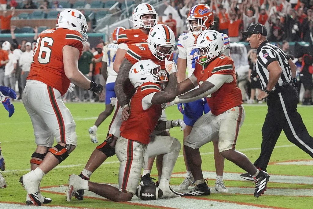 Miami running back CharMar Brown (6), center, celebrates with his teammates after scoring a touchdown during the second half of an NCAA college football game against Florida, Saturday, Sept. 20, 2025, in Miami Gardens, Fla. (AP Photo/Marta Lavandier)