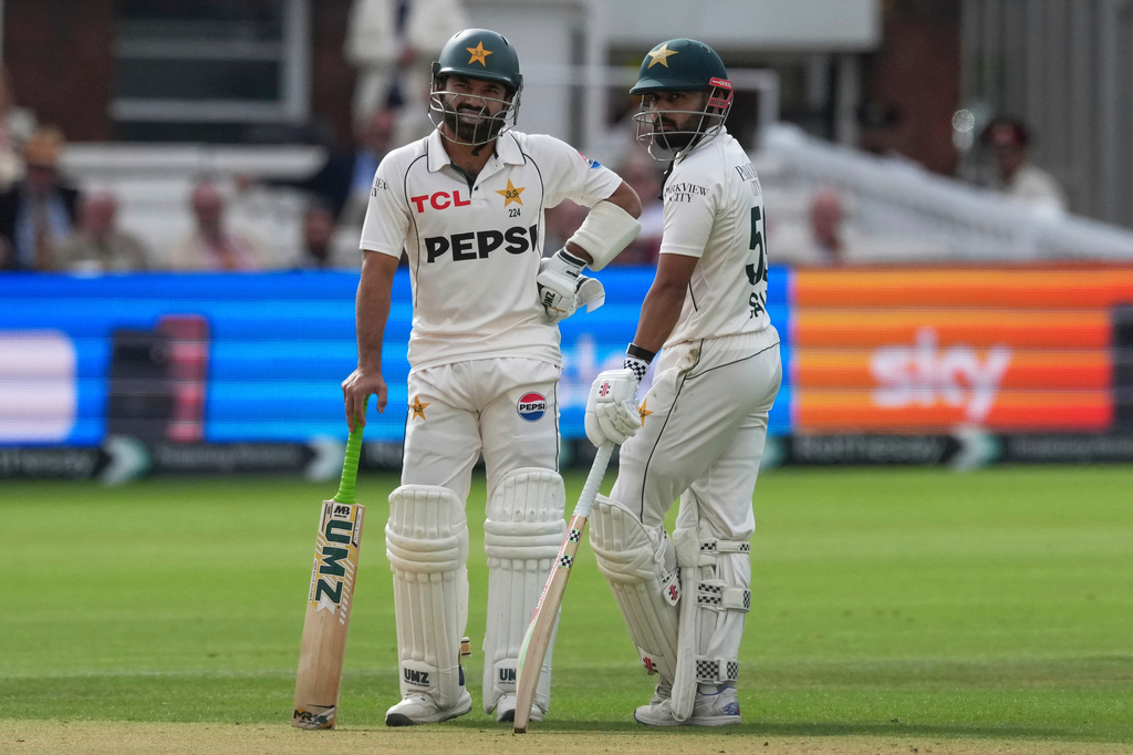 Pakistan's Mohammad Rizwan, left, stands with batting partner Saud Shakeel as they await third umpire's decision on Rizwan's wicket on day four of the second cricket test match between England and Pakistan in London, Sunday, Aug. 30, 2026. (AP Photo/Dave Shopland)