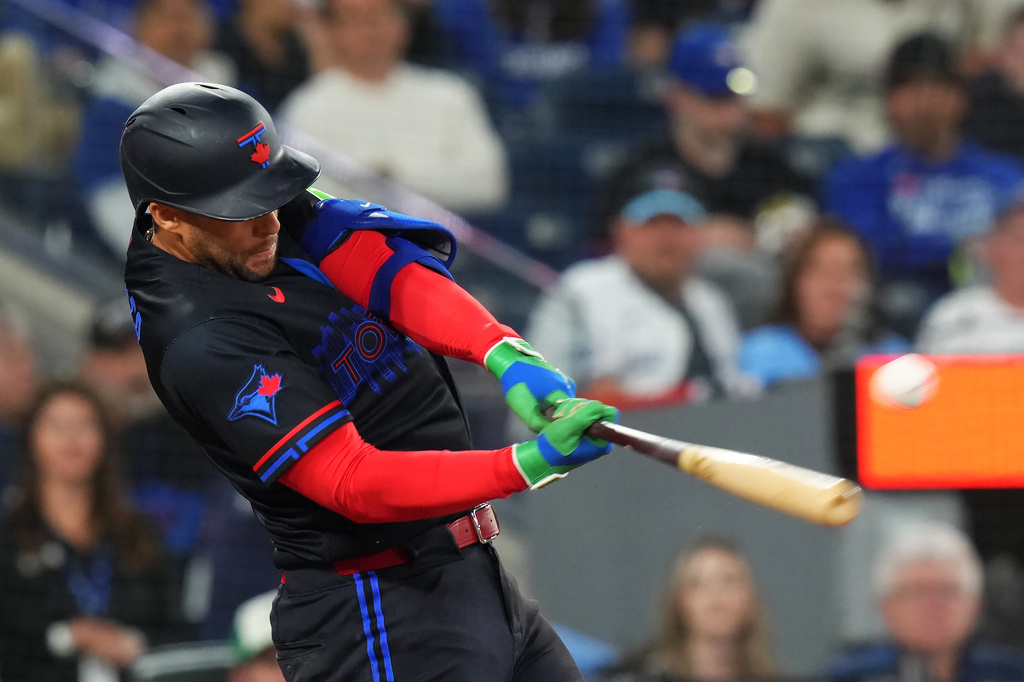 Toronto Blue Jays designated hitter George Springer hits an RBI double against the Minnesota Twins during sixth-inning baseball game action in Toronto, Friday, April 10, 2026. (Chris Young/The Canadian Press via AP)