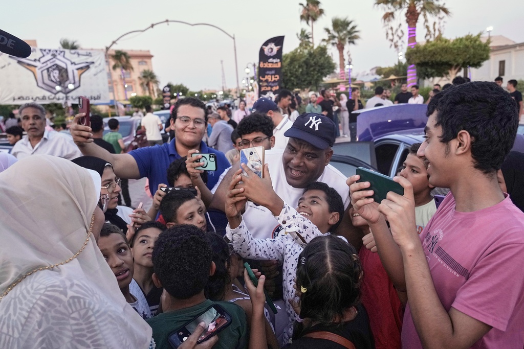 Egyptian wrestler Ashraf Mahrous, also known by his nickname Kabonga, is greeted by fans after attempting to pull 20 vehicles at Al Safaa Club in 10th of Ramadan City, outside Cairo, Egypt, Friday, Aug. 1, 2025. (AP Photo/Amr Nabil)