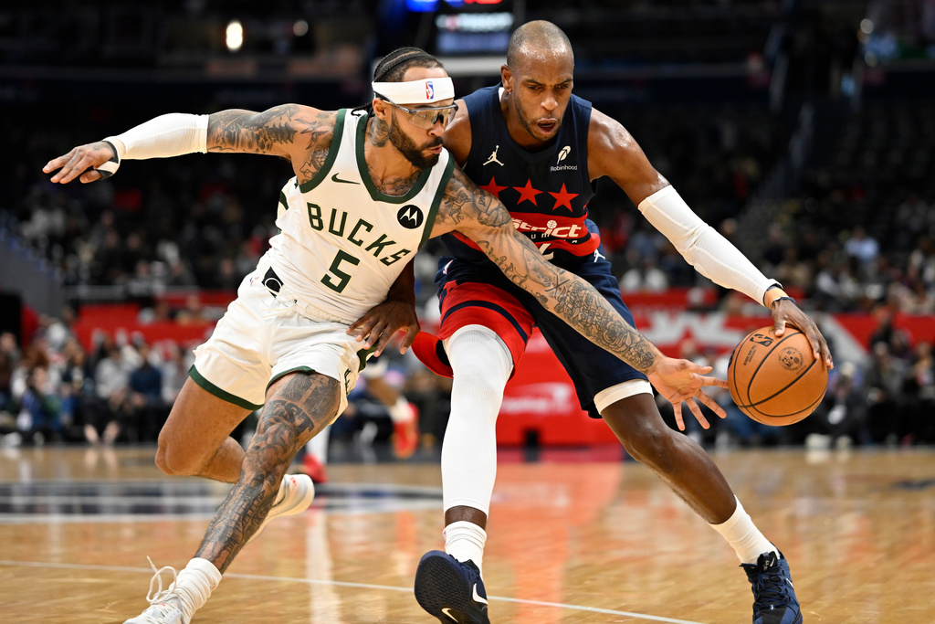 Washington Wizards forward Khris Middleton, right, drives to the basket against Milwaukee Bucks guard Gary Trent Jr. (5) during the first half of an NBA basketball game Monday, Dec. 1, 2025, in Washington. (AP Photo/John McDonnell)