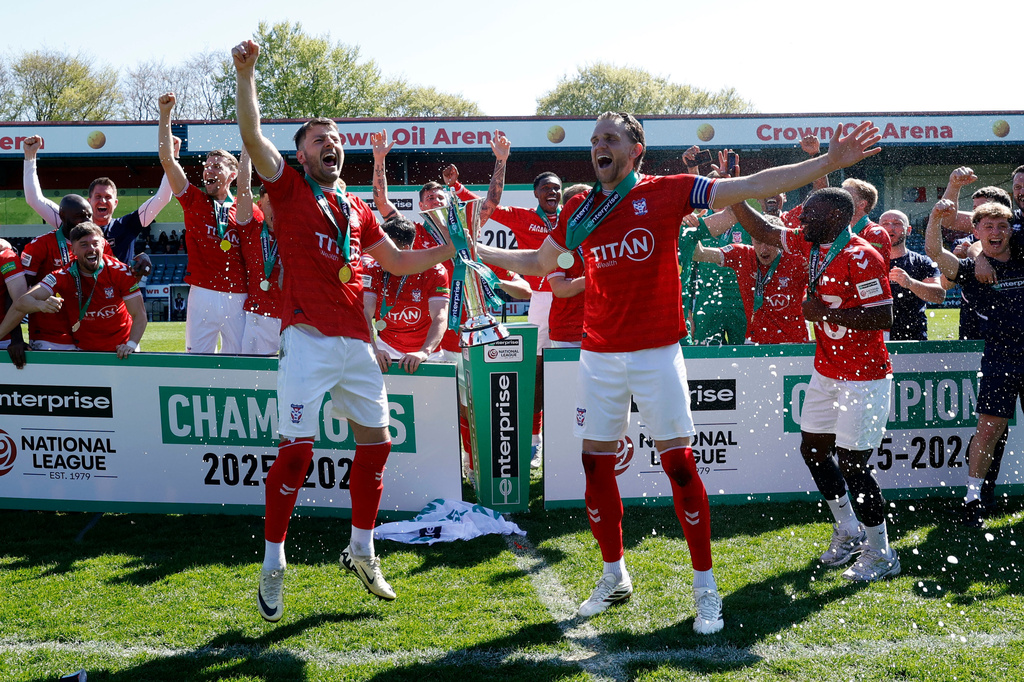 York City players and staff celebrate with the trophy after defeating Rochdale in the National League match in Rochdale, England, Saturday April 25, 2026. (Cody Froggatt/PA via AP)