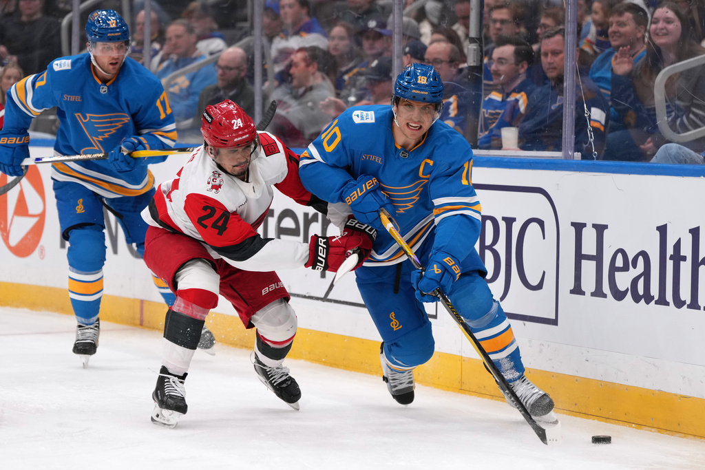 St. Louis Blues' Brayden Schenn (10) looks to pass as Carolina Hurricanes' Seth Jarvis (24) defends during the third period of an NHL hockey game Tuesday, Jan. 13, 2026, in St. Louis. (AP Photo/Jeff Roberson)