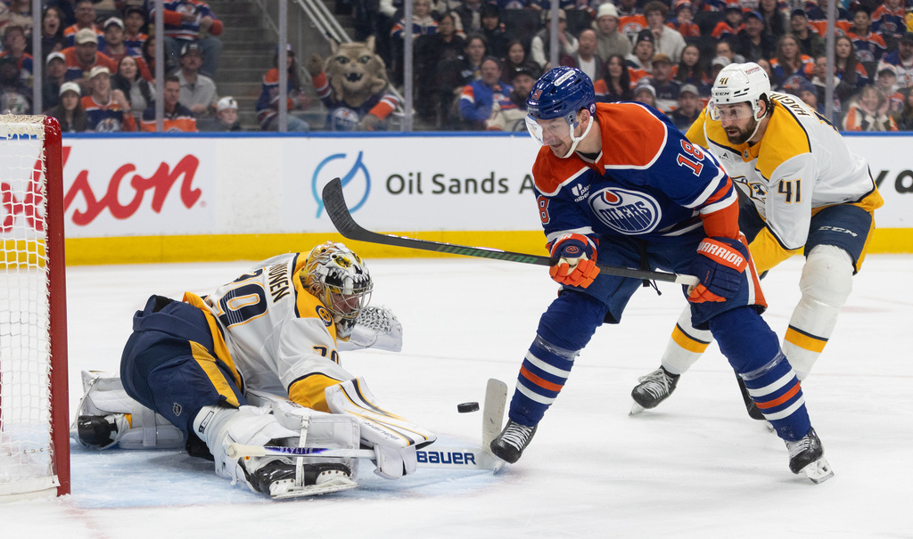 Nashville Predators goalie Justus Annunen, left, makes a save on Edmonton Oilers' Zach Hyman (18) during the second period of an NHL hockey game in Edmonton, Alberta, Sunday, March 15, 2026. (Jason Franson/The Canadian Press via AP)