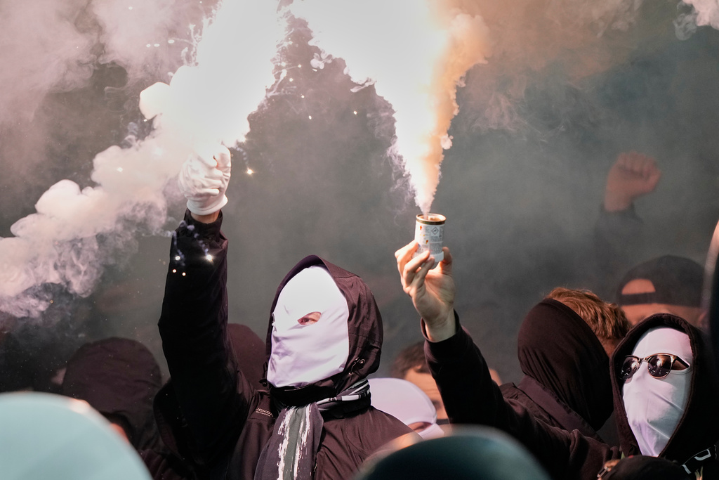 Moenchengladbach fans burn fireworks during the German Bundesliga soccer match between Borussia Dortmund and Borussia Moenchengladbach in Dortmund, Germany, Friday, Dec. 19, 2025. (AP Photo/Martin Meissner)
