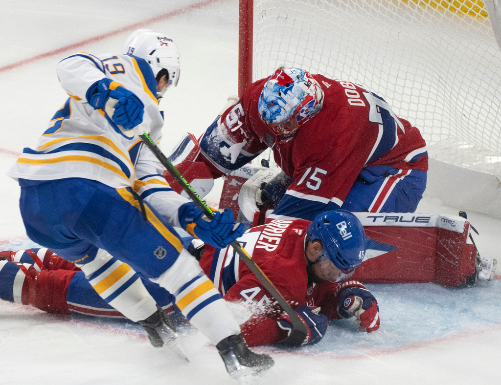 Montreal Canadiens' Alexandre Carrier (45) blocks a rebound shot by Buffalo Sabres' Peyton Krebs (19) in front of goaltender Jakub Dobes (75) during third period NHL hockey action in Montreal on Monday, Oct. 20, 2025. (Christinne Muschi/The Canadian Press via AP)