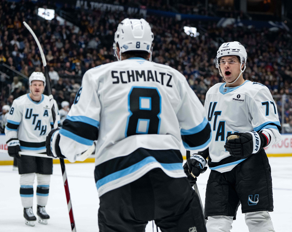 Utah Mammoth's JJ Peterka (77) celebrates after a goal by teammate Nick Schmaltz (8) against the Vancouver Canucks during the second period of an NHL hockey game in Vancouver, British Columbia, Friday, Dec. 5, 2025. (Ethan Cairns/The Canadian Press via AP)