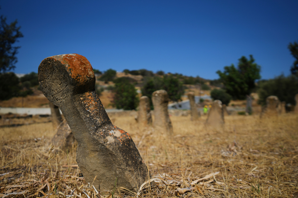 A headstone at the grave of a Turkish Cypriot man lies slightly tilted at the Muslim cemetery in the village of Tochni, Cyprus on July 3, 2025. (AP Photo/Petros Karadjias)