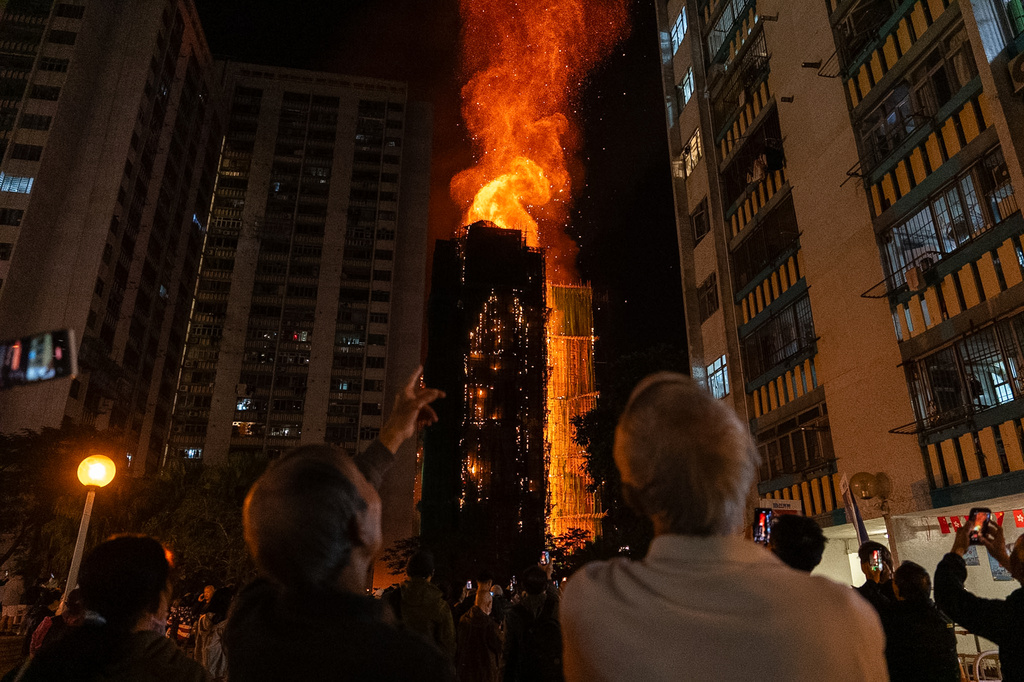 People look at flames engulfing a building after a fire broke out at Wang Fuk Court, a residential estate in the Tai Po district of Hong Kong's New Territories, Wednesday, Nov. 26 2025. (AP Photo/Chan Long Hei, File)