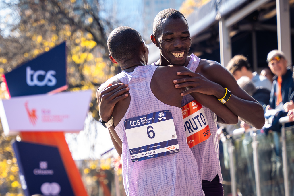 Benson Kipruto and Alexander Mutiso and hug and laugh with each other after a close finish crossing the finish line to win first and second place in the men's elite division of the New York City Marathon, Sunday, Nov. 2, 2025, in New York. (AP Photo/Angelina Katsanis)