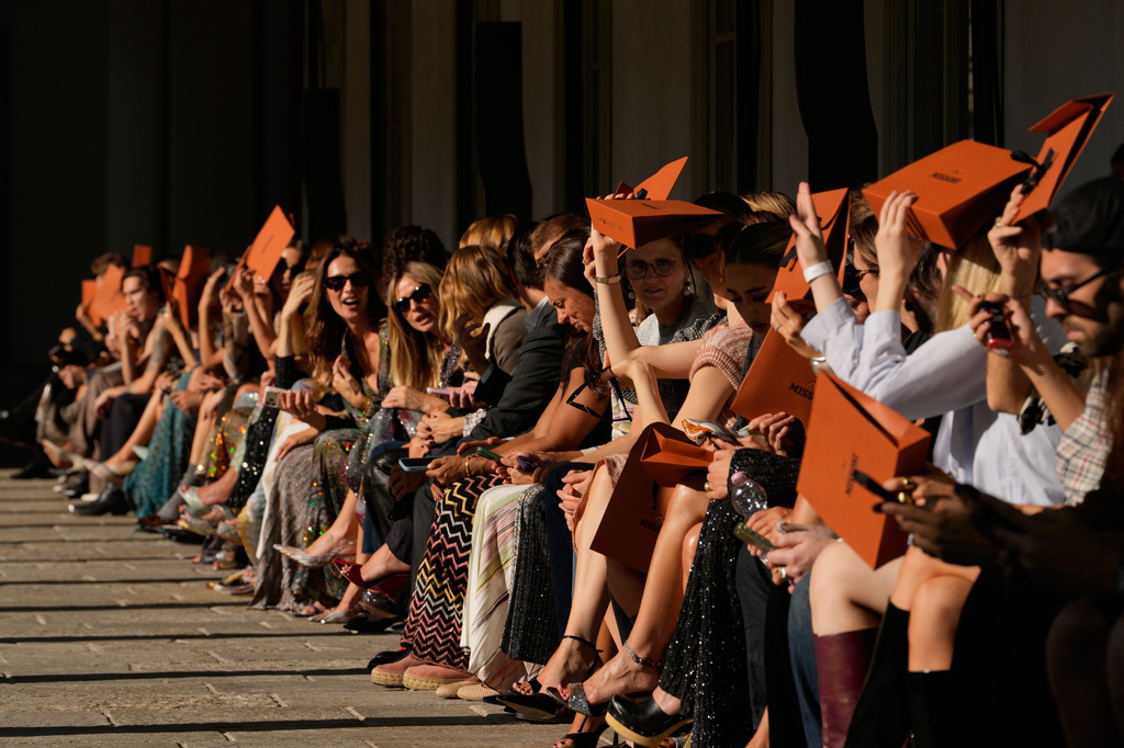Guests shelter from the sun during the Missoni women's Spring-Summer 2027 fashion show, presented in Milan, Italy, Wednesday, Sept. 23, 2026. (AP Photo/Luca Bruno)