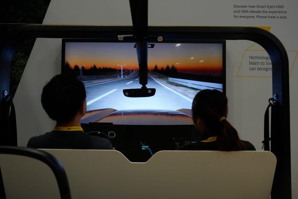 People take part in a simulator for Smart Eye interior sensing AI technology at the Smart Eye booth during the CES tech show Tuesday, Jan. 6, 2026, in Las Vegas. (AP Photo/John Locher)
