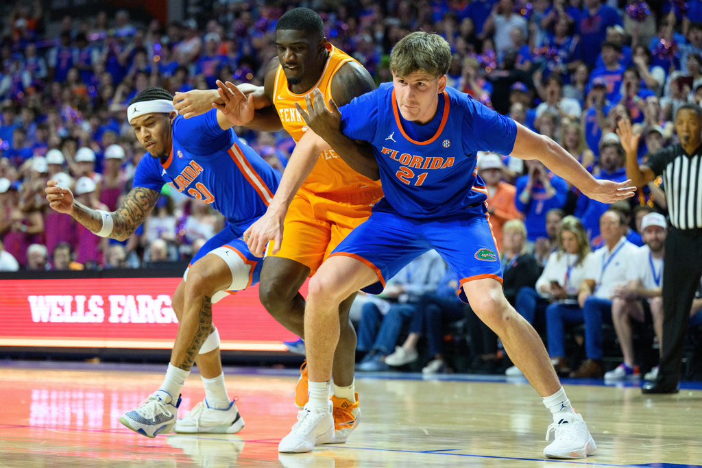 Florida forward Alex Condon (21) and guard Isaiah Brown (20) box out against Tennessee forward DeWayne Brown II (6) during the first half of an NCAA college basketball game, Saturday, Jan. 10, 2026, in Gainesville, Fla. (AP Photo/Noah Lantor)