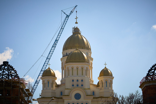 FILE - Construction workers install the main cross of the National Cathedral, in Bucharest, Romania, Tuesday, April 8, 2025. (AP Photo/Vadim Ghirda, File) FILE - Construction workers install the main cross of the National Cathedral, in Bucharest, Romania, Tuesday, April 8, 2025. (AP Photo/Vadim Ghirda, File)