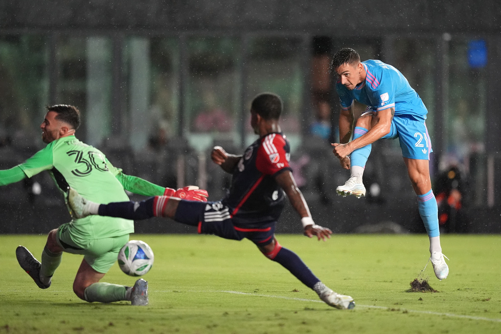 Inter Miami forward Tadeo Allende (21) scores his side's first goal past New England Revolution goalkeeper Matt Turner (30) and defender Brayan Ceballos during the first half of an MLS soccer match, Saturday, Oct. 4, 2025, in Fort Lauderdale, Fla. (AP Photo/Rebecca Blackwell)