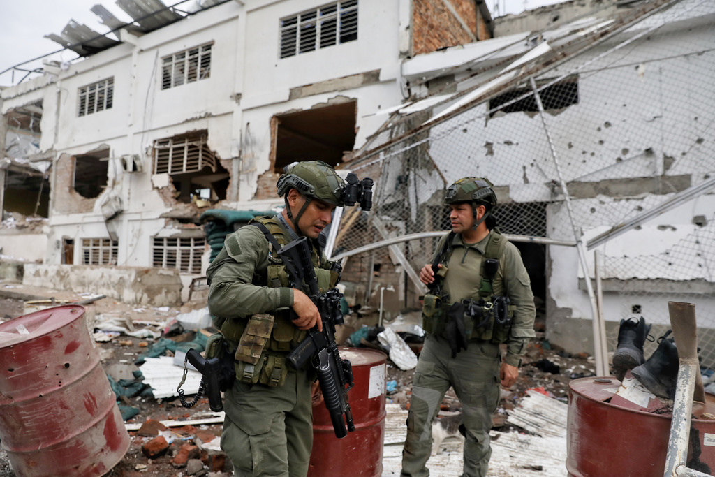 Police inspect buildings destroyed in an attack the government blamed on dissidents of the Revolutionary Armed Forces of Colombia (FARC), in Buenos Aires, Colombia, Wednesday, Dec. 17, 2025. (AP Photo/Santiago Saldarriaga)