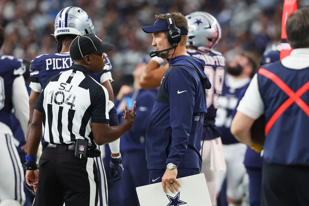 Dallas Cowboys head coach Brian Schottenheimer talks to a referee during the second half of an NFL football game against the Los Angeles Chargers, Sunday, Dec. 21, 2025, in Arlington, Texas. (AP Photo/Richard W. Rodriguez)