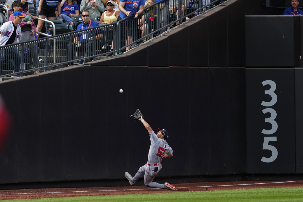 Washington Nationals outfielder Daylen Lile attempts to catch a fly ball by New York Mets' Cedric Mullins during the third inning of a baseball game against the New York Mets, Sunday, Sept. 21, 2025, in New York. (AP Photo/Yuki Iwamura)