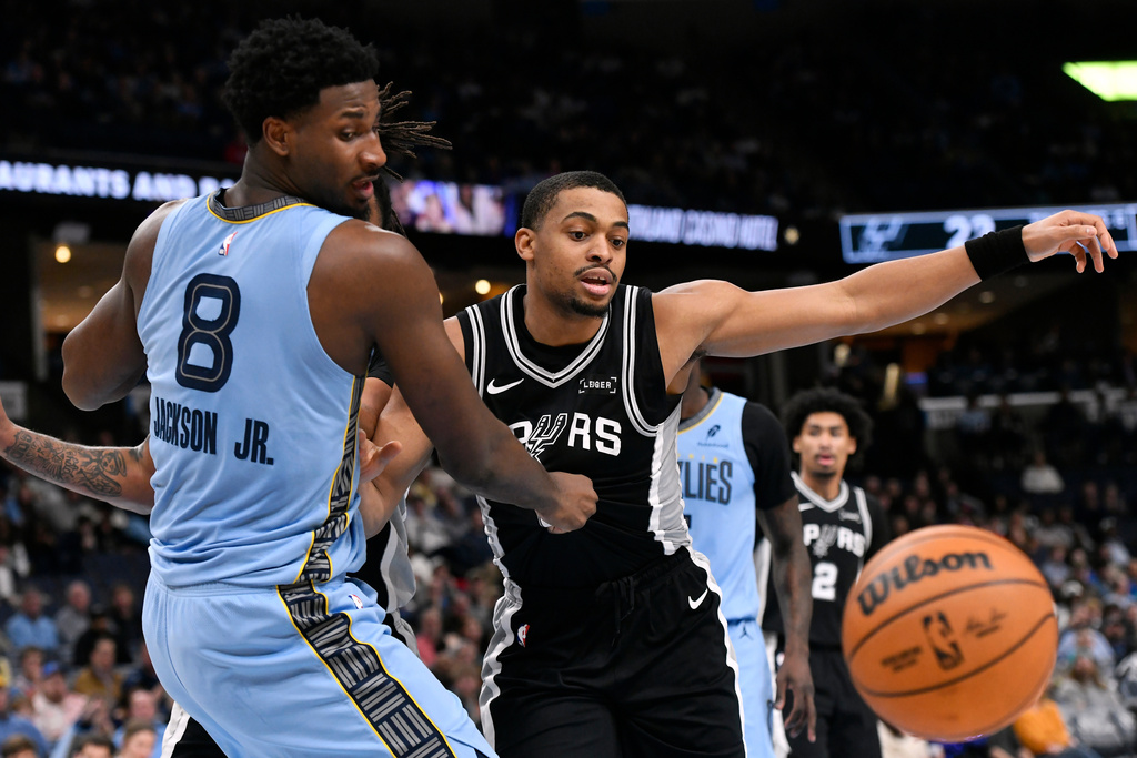 Memphis Grizzlies forward Jaren Jackson Jr. (8) and San Antonio Spurs forward Keldon Johnson, right, move for the ball in the first half of an NBA basketball game, Tuesday, Jan. 6, 2026, in Memphis, Tenn. (AP Photo/Brandon Dill)