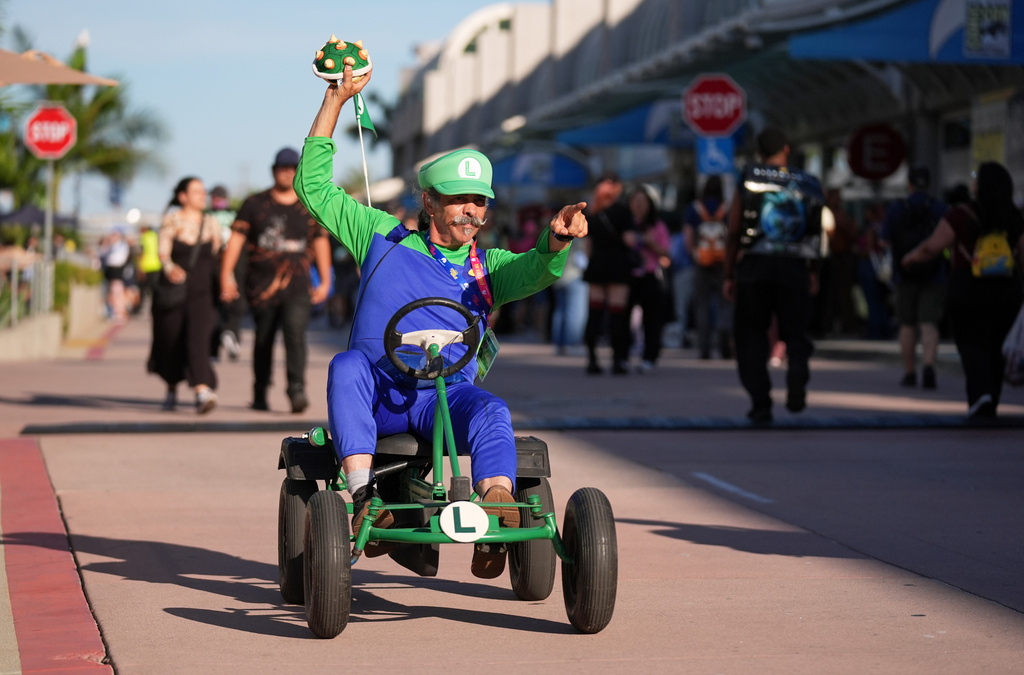 Matt Armstrong, of San Diego, dressed as the character Luigi from the Mario Kart video game series, greets attendees during preview night for Comic-Con International on Wednesday, July 22, 2026, in San Diego. (AP Photo/Chris Pizzello)