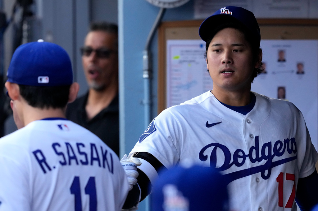 Los Angeles Dodgers starting pitcher Roki Sasaki, left, greets Shohei Ohtani I. The dugout prior to a baseball game against the Los Angeles Angels, Friday, June 5, 2026, in Los Angeles. (AP Photo/Mark J. Terrill)