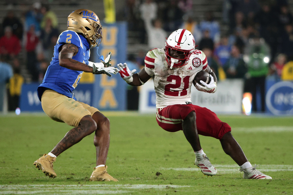 Nebraska running back Emmett Johnson (21) is defended by UCLA defensive back Andre Jordan Jr. (2) during the second half of an NCAA college football game Saturday, Nov. 8, 2025, in Pasadena, Calif. (AP Photo/Ethan Swope)