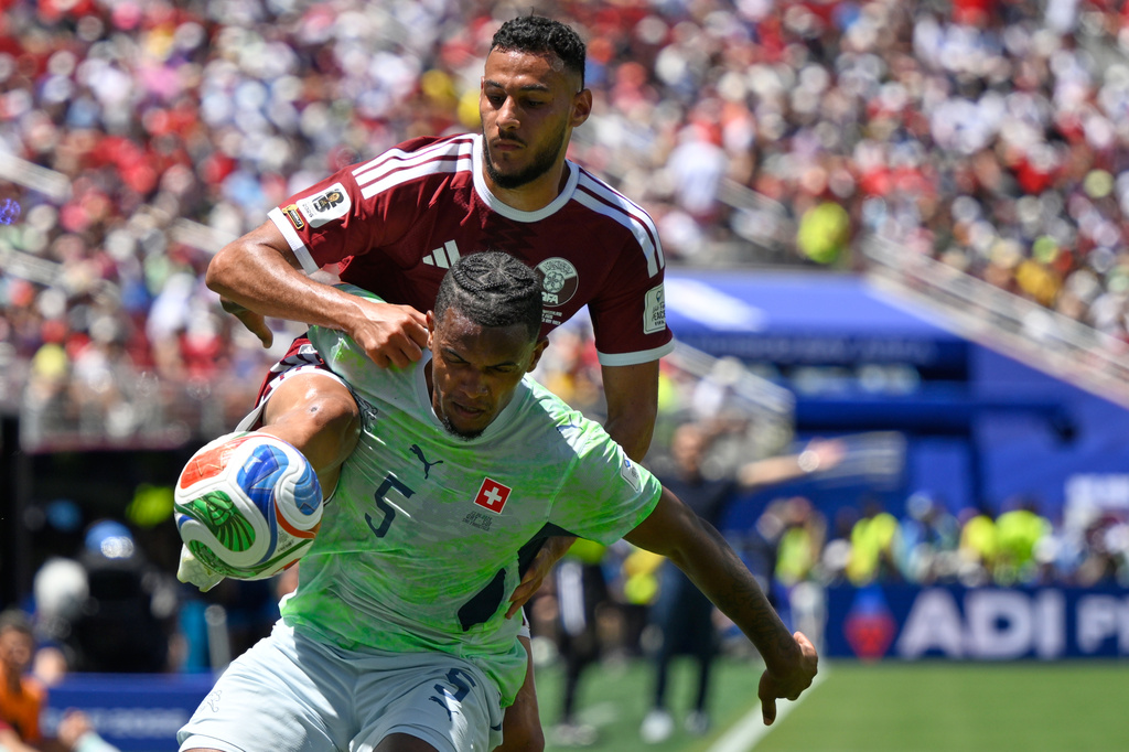 Qatar's Mohamed Manai attempts to get the ball as Switzerland's Manuel Akanji defends during the World Cup Group B soccer match between Qatar and Switzerland in Santa Clara, Calif., near San Francisco, Saturday, June 13, 2026. (AP Photo/Eakin Howard)