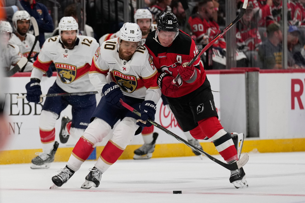 Florida Panthers' A.J. Greer, left, and New Jersey Devils' Ondrej Palat make contact during the first period of an NHL hockey game Thursday, Oct. 16, 2025, in Newark, N.J. (AP Photo/Seth Wenig)
