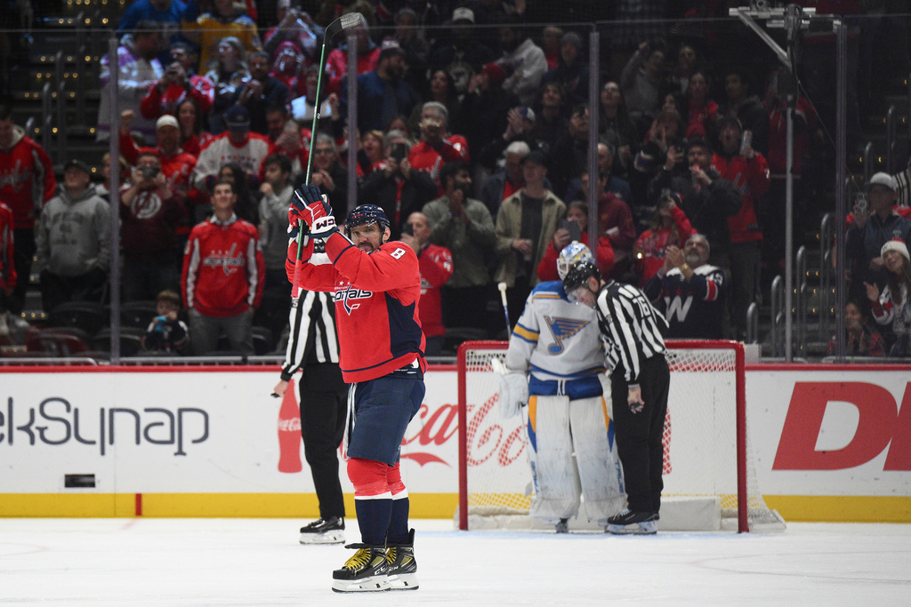 Washington Capitals left wing Alex Ovechkin (8) celebrates his 900th career NHL goal as linesman Brandon Grillo (75) talks with St. Louis Blues goaltender Jordan Binnington (50) the second period of an NHL hockey game, Wednesday, Nov. 5, 2025, in Washington. (AP Photo/Nick Wass)