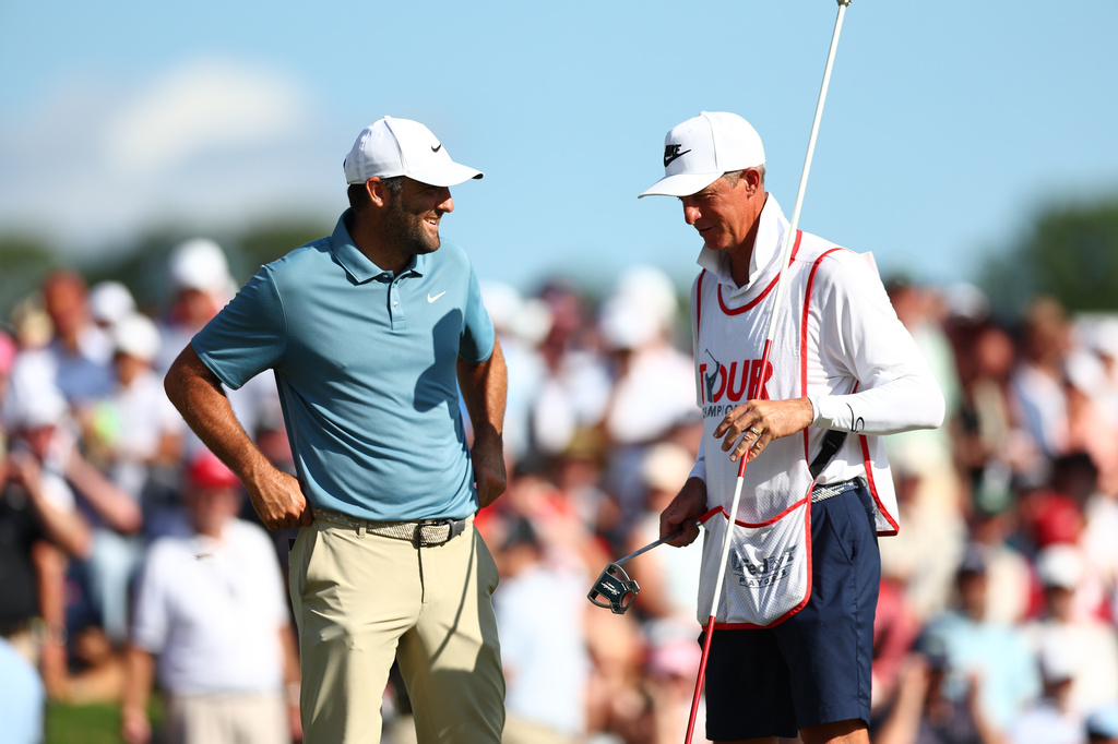 Scottie Scheffler talk to his caddie on the18th green during the final round of the PGA Tour Championship golf tournament Sunday, Aug. 30, 2026, in Atlanta. (AP Photo/Colin Hubbard)