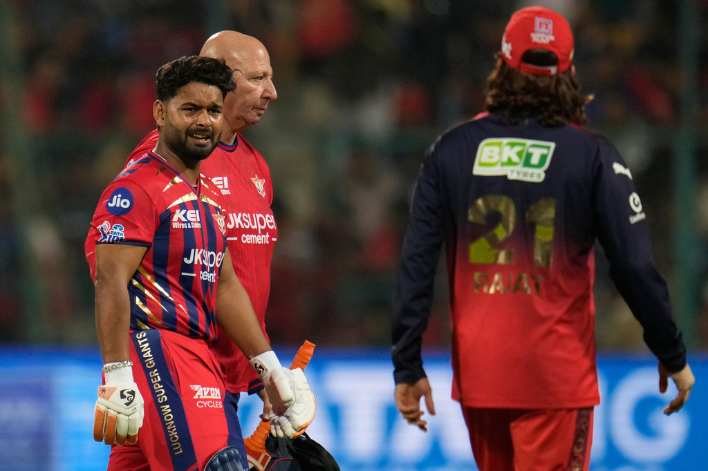 Lucknow Super Giants' captain Rishabh Pant, left, leaves the field after retired hurt during the Indian Premier League cricket match between Royal Challengers Bengaluru and Lucknow Super Giants in Bengaluru, India, Wednesday, April 15, 2026. (AP Photo/Aijaz Rahi)
