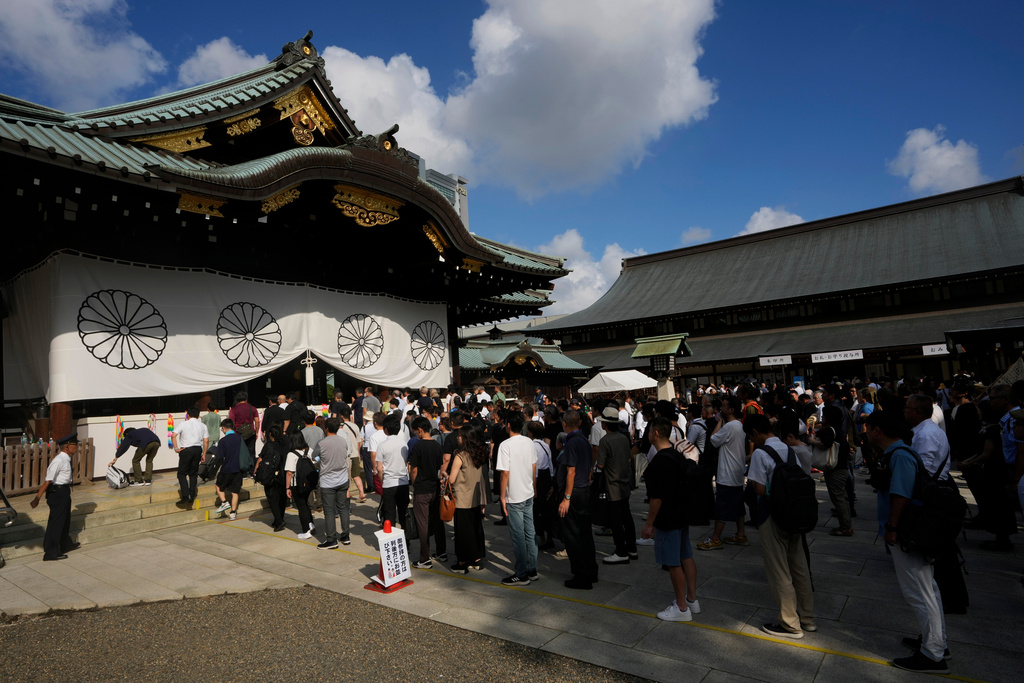 FILE -People wait in queue before reaching to the front to pray at the main hall at Yasukuni Shrine, which honors Japan's war dead, in Tokyo, Japan, Aug. 15, 2024, as the country marks the 79th anniversary of its defeat in the World War II. (AP Photo/Hiro Komae, File)