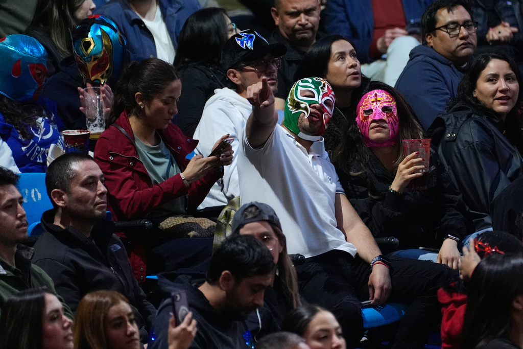 Wrestling fans wear masks during a live Lucha Libre performance at Arena Mexico in Mexico City, Friday, Feb. 6, 2026. (AP Photo/Marco Ugarte)