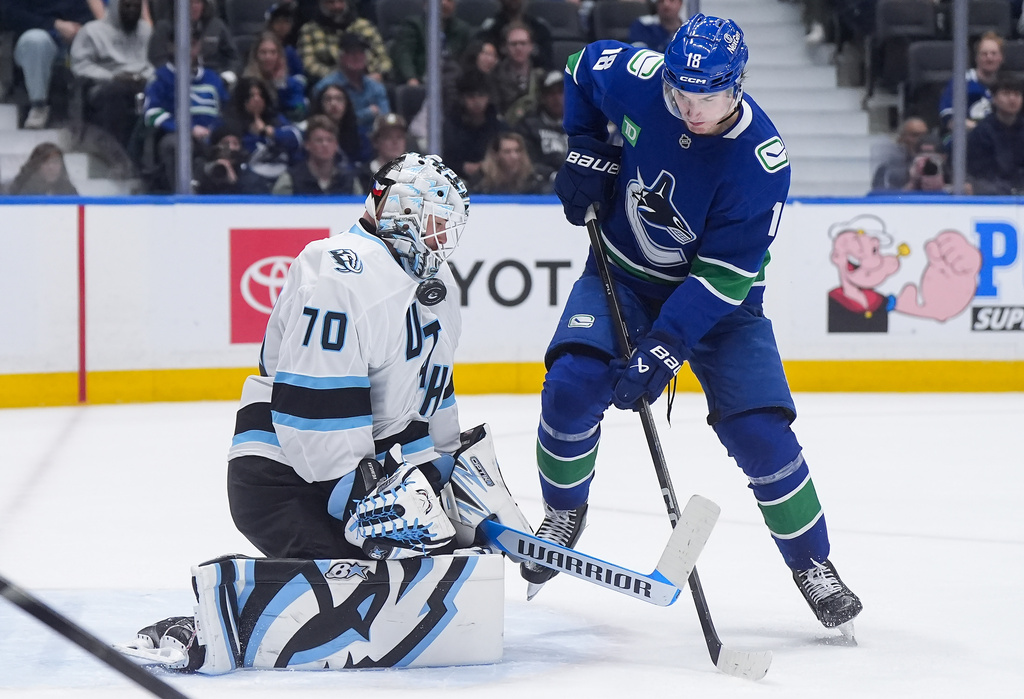 Utah Mammoth goalie Karel Vejmelka (70) makes the save as Vancouver Canucks' Drew O'Connor (18) stands in front of him during the third period of an NHL hockey game, in Vancouver, on Saturday, April 4, 2026. (Darryl Dyck/The Canadian Press via AP)
