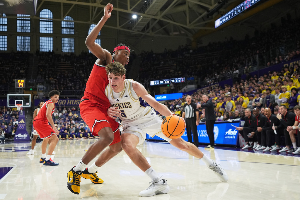 Washington forward Hannes Steinbach (6) drives against Ohio State forward Amare Bynum, left, during the first half of an NCAA college basketball game Sunday, Jan. 11, 2026, in Seattle. (AP Photo/Lindsey Wasson)