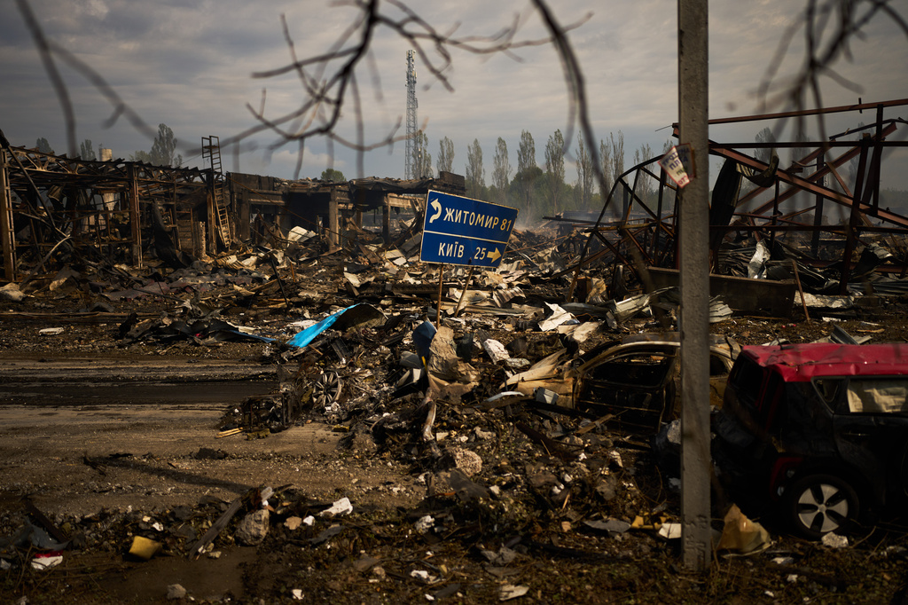 Destroyed vehicles and debris are scattered the day after a Russian attack struck a warehouse, followed by an explosion, in the village of Myla, outskirts of Kyiv, Sunday, Aug. 30, 2026. (AP Photo/Francisco Seco)