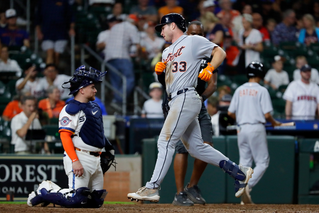 Detroit Tigers' Colt Keith (33) scores on his third home run of a baseball game near Houston Astros catcher Christian Vazquez, left, during the ninth inning of a baseball game Monday, June 15, 2026, in Houston. (AP Photo/Michael Wyke)
