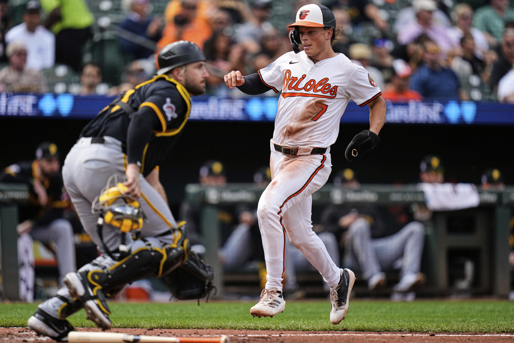Baltimore Orioles' Jackson Holliday (7) scores past Pittsburgh Pirates catcher Joey Bart, left, on an RBI single hit by Dylan Beavers during the seventh inning of a baseball game, Thursday, Sept. 11, 2025, in Baltimore. (AP Photo/Stephanie Scarbrough)