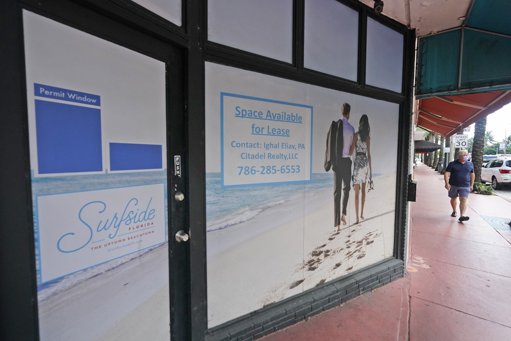 A pedestrian walks past an empty business available for lease, Monday, Oct. 12, 2020, in downtown Surfside, Fla. (AP Photo/Wilfredo Lee)