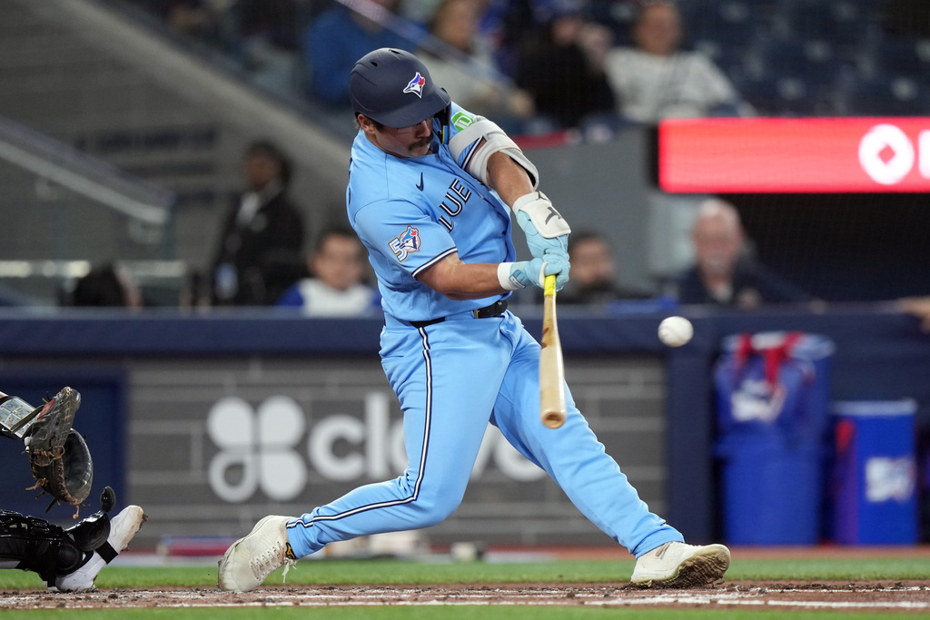 Toronto Blue Jays' Davis Schneider (36) hits an RBI double during the third inning of a baseball game against the Colorado Rockies, Wednesday, April 1, 2026, in Toronto. (Nathan Denette/The Canadian Press via AP)